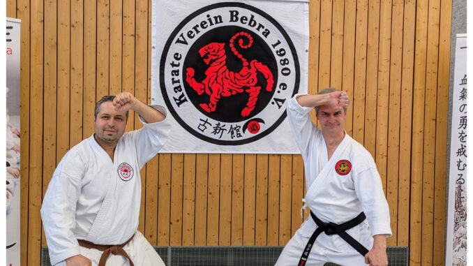 Bild1-Bebra17052025 von links: Belal Chahrour und Paul Miller. Zwei alte Karateka Freunde aus Studienzeiten in der Sochin dachi Stellung vor dem Logo des Karate Verein Bebra.